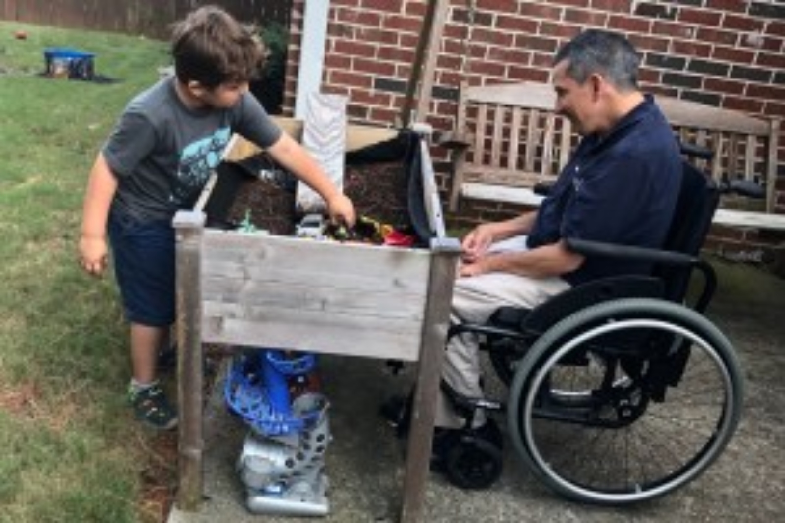 Glenn and his son playing in dirt box