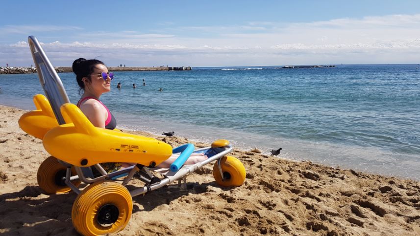 Emma on the beach in a beach wheelchair