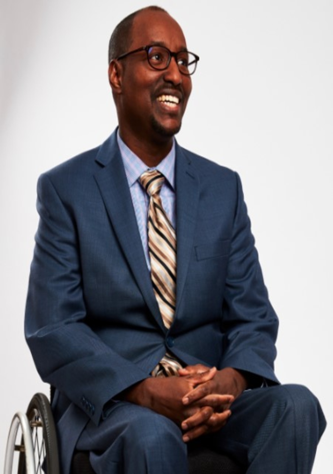 Abdi in business attire smiling