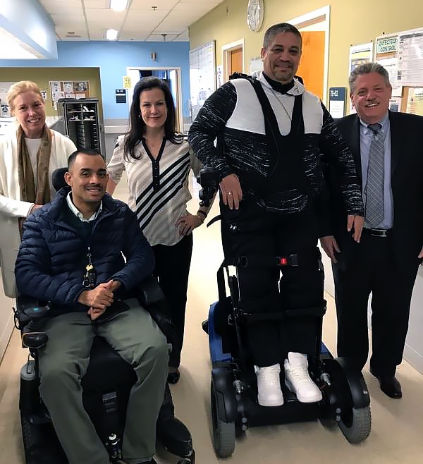The United Spinal and VetsFirst team with a patient demonstrating the latest in sit-to-stand wheelchair technology at James J. Peters VA Medical Center.