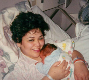 Stefanowicz in hospital bed holding newborn baby