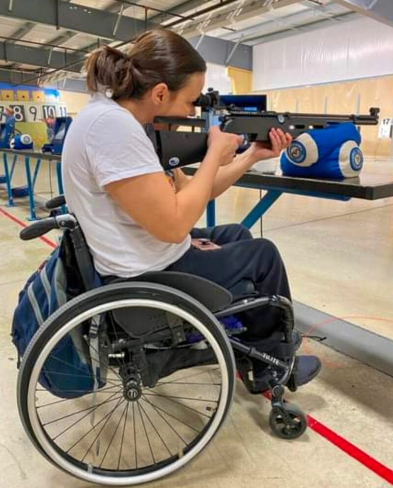 Tenesha aiming a rifke at an indoor shooting range