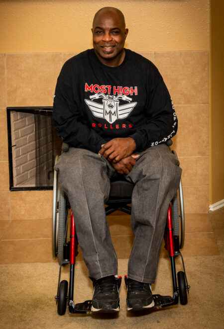 full view of man in powerchair smiling for camera