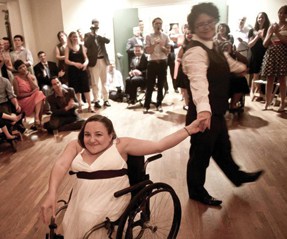 Two brides dance, one uses a wheelchair.
