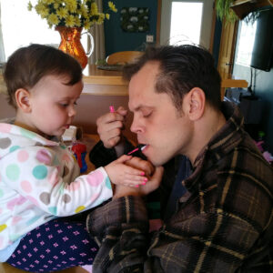 Ouellette painting young nieces nails using brush with mouth