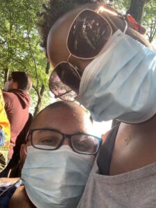 A selfie of a seated black man and standing black woman