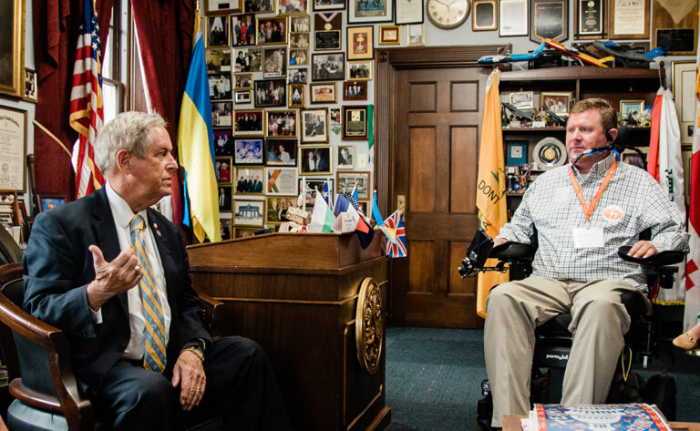 man in powerchair with congressman in his office