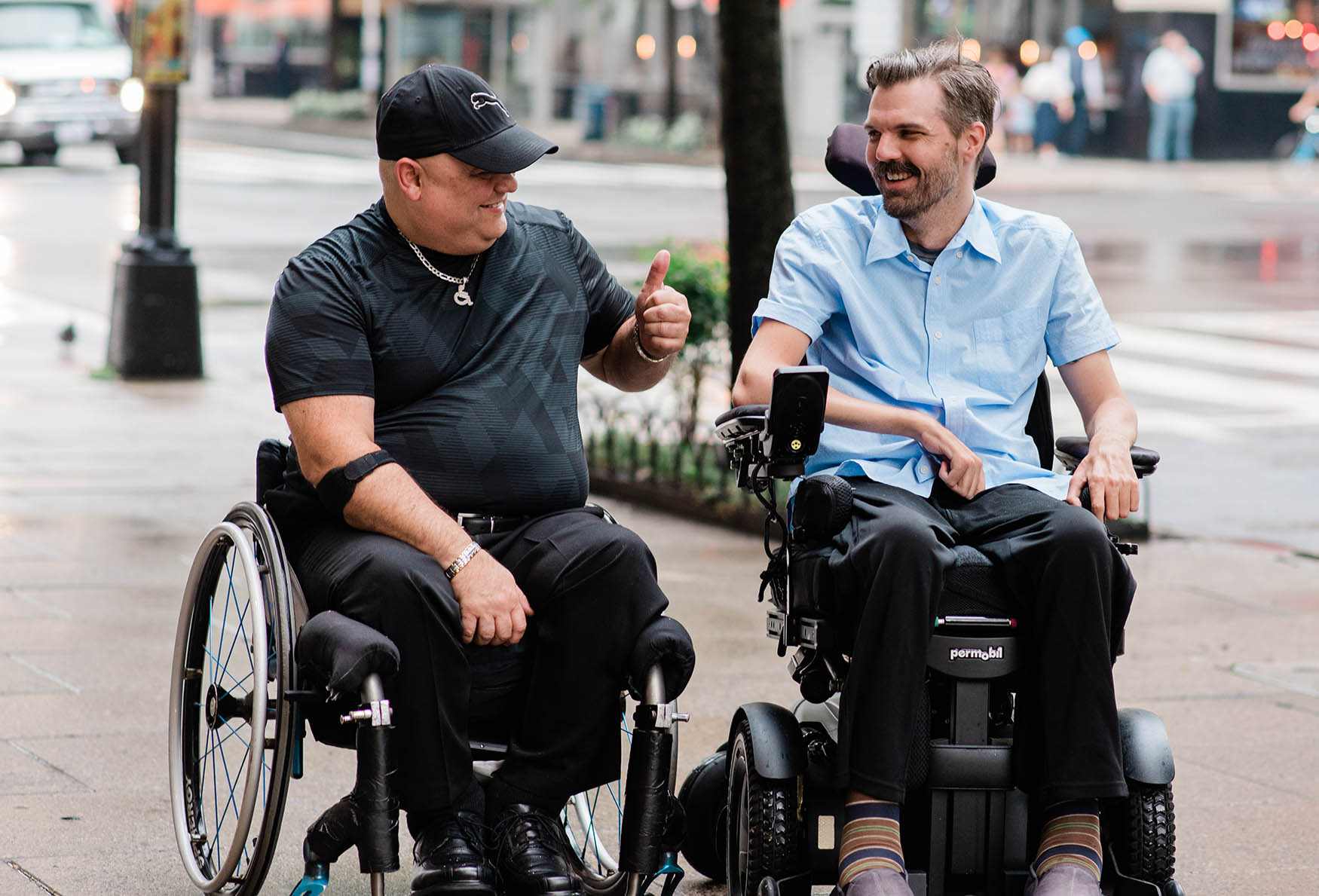 Two wheelchair users talk to each other