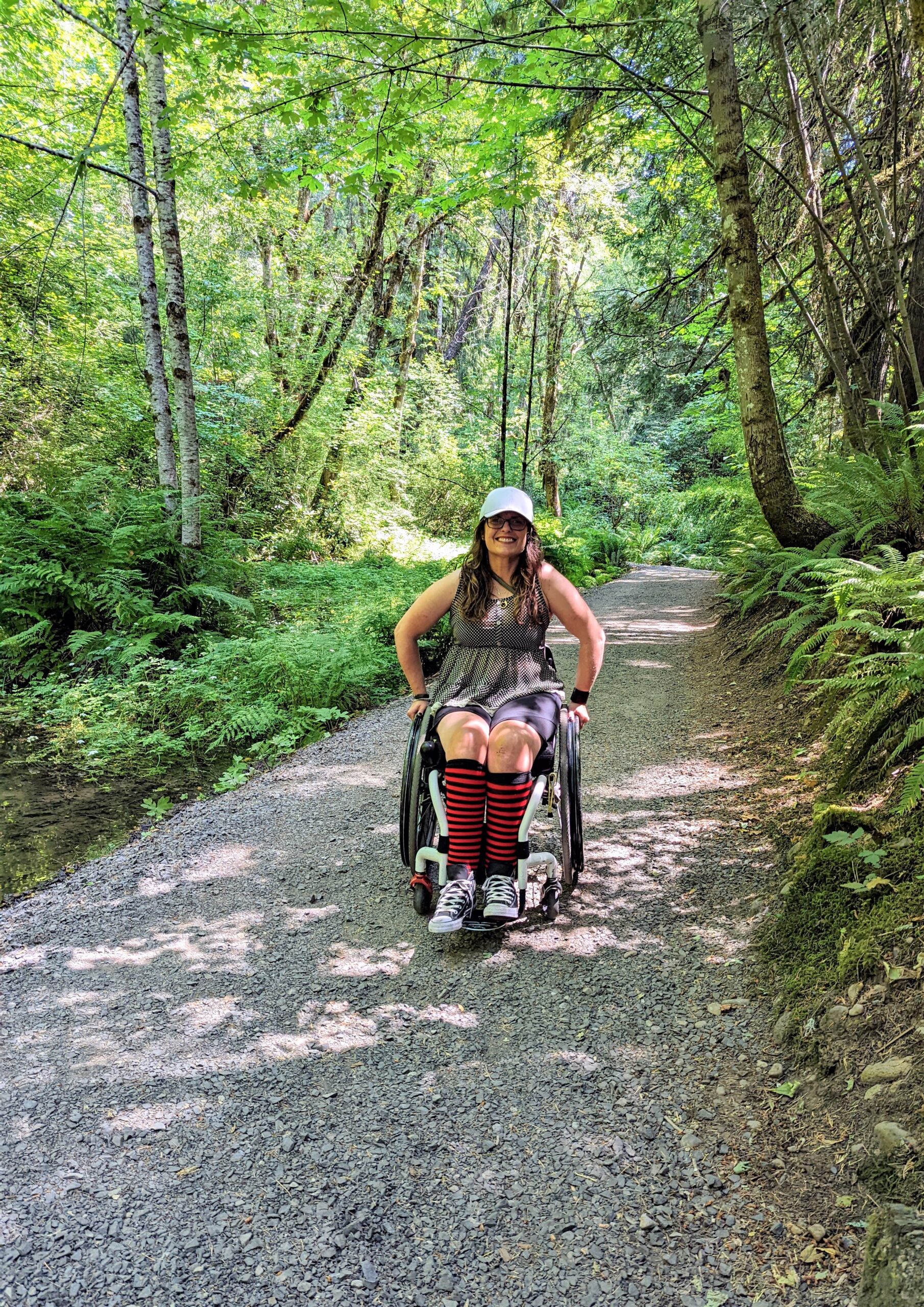 woman in wheelchair on a path in the woods