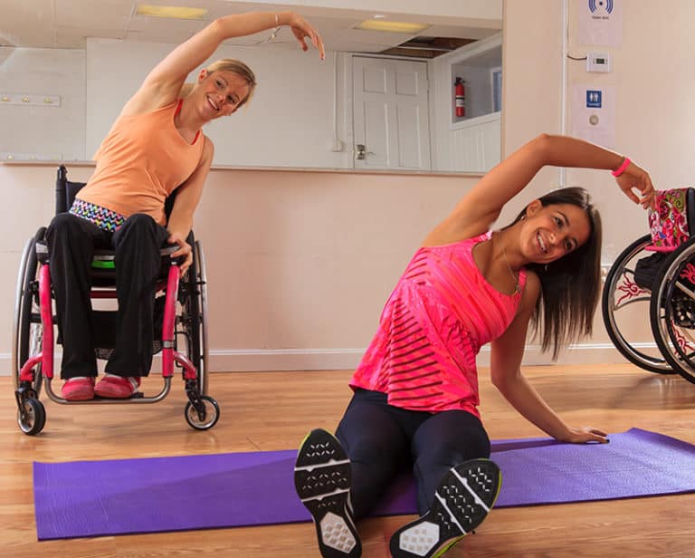 two wheelchair users doing yoga
