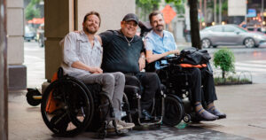 Three smiling wheelchair users