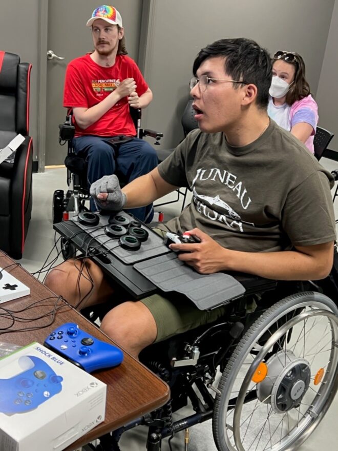 manm in wheelchair using adaptive controller to play video game