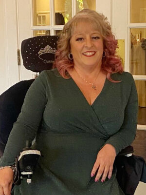 woman in powerchair smiling at camera