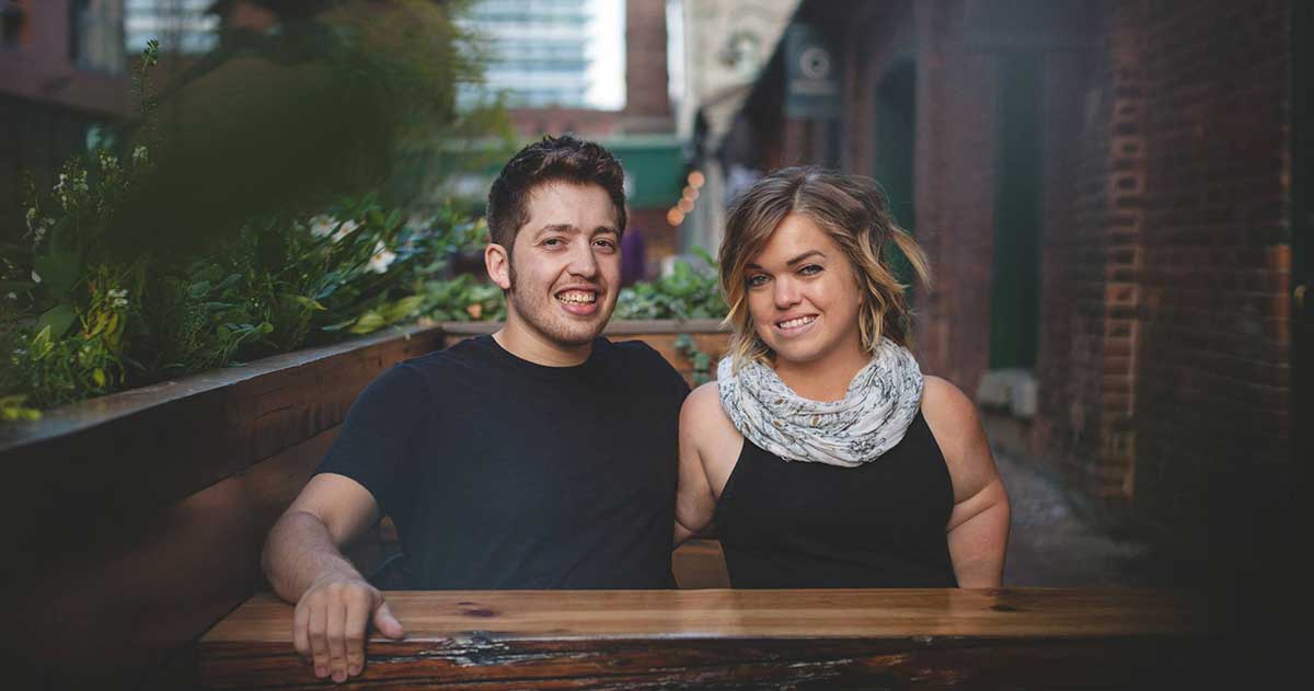 man and woman with arms around each other smiling at camera