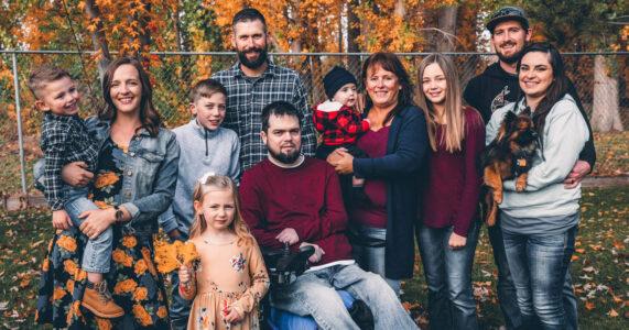 Family photo with several family members including children, man in wheelchair