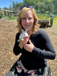 Char Vine holds a rabbit and smiles at the camera