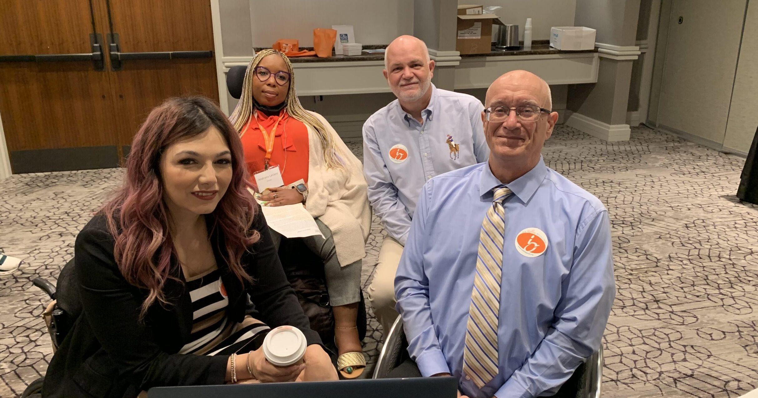 two men and two women sit in wheelchairs in front of a computer during united spinal's advocacy meeting