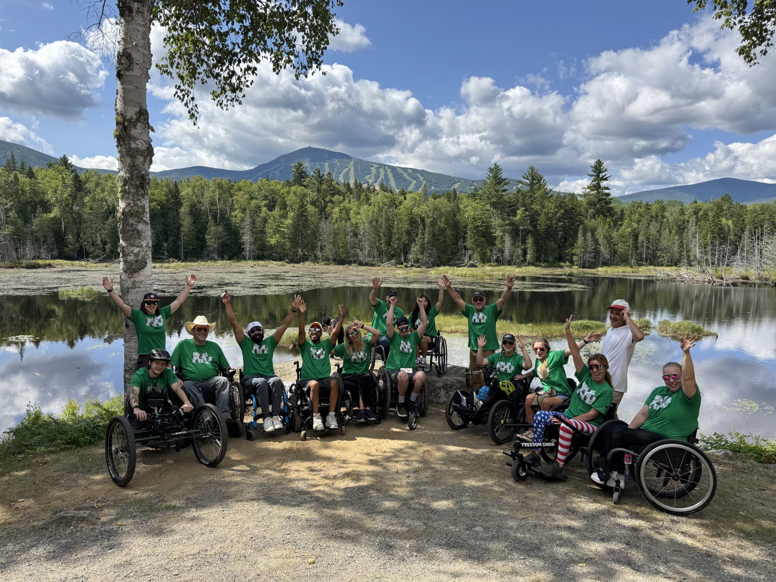 AEOC group photo taken in front of lake with mountains in the background