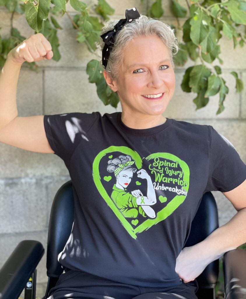 smiling woman in wheelchair with raised fist