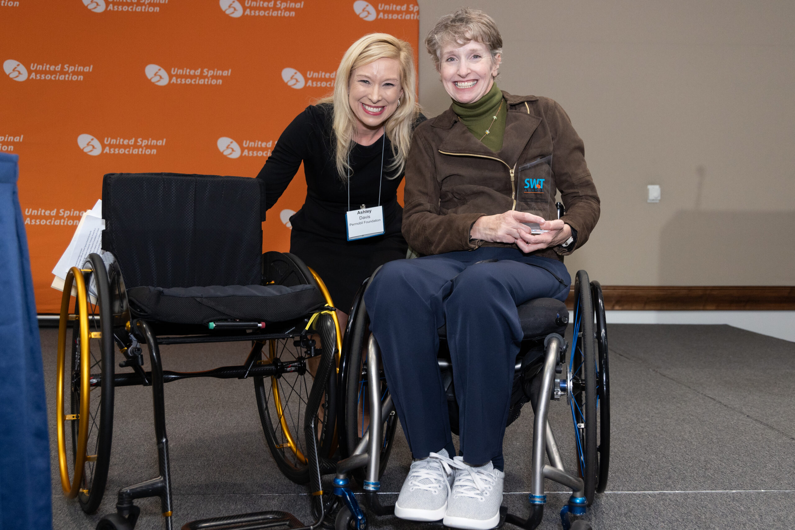 A woman in a wheelchair at the StrongWheeled Together Awards next to her prize wheelchair