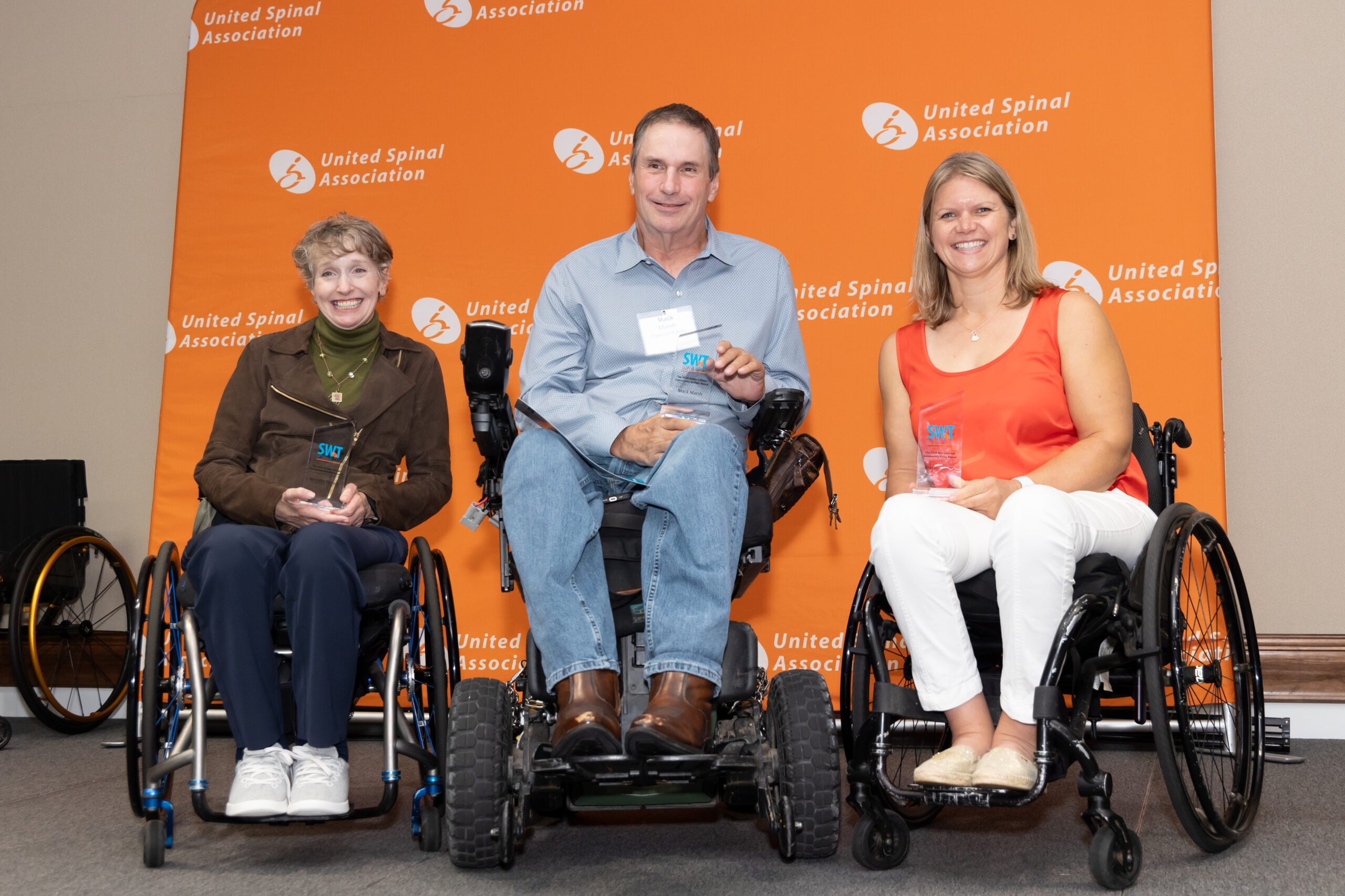 three wheelchair users posing with their awards