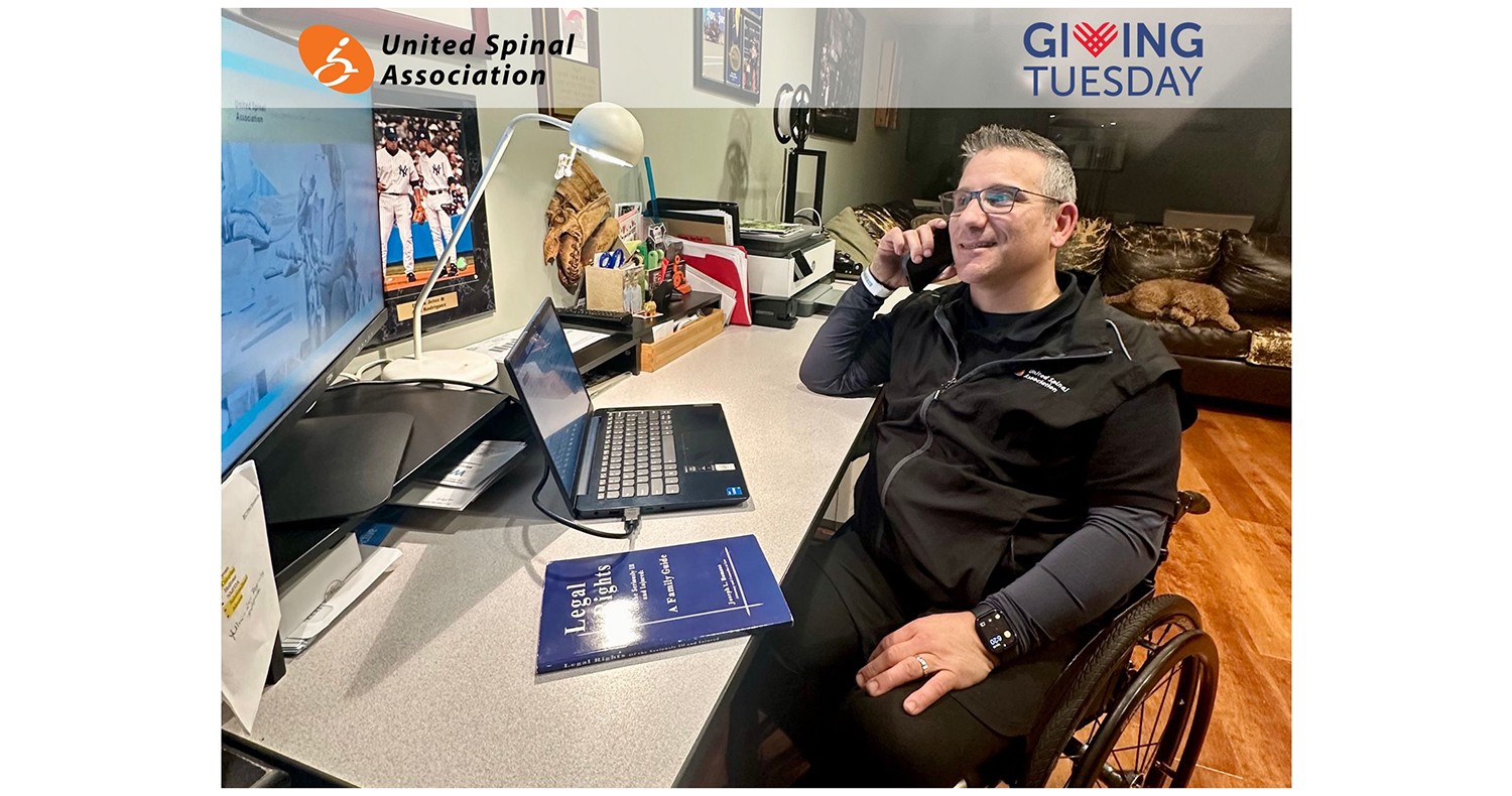 a man in a wheelchair smiles on the phone