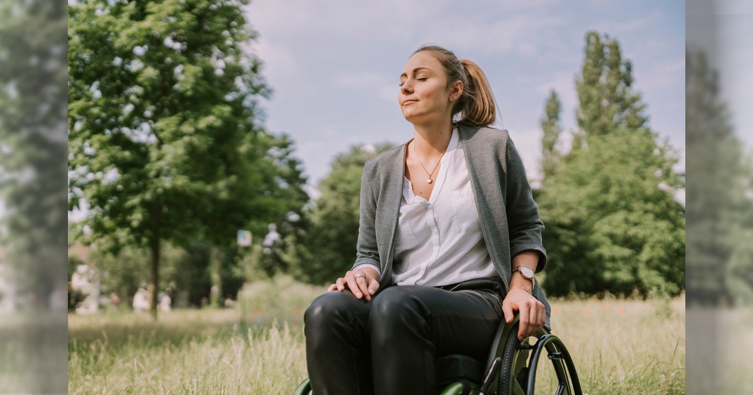 Disabled woman with eyes closed in park