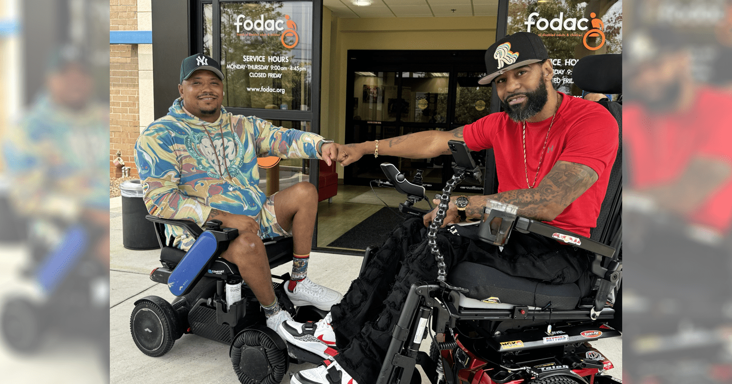 two men in wheelchairs fist bump