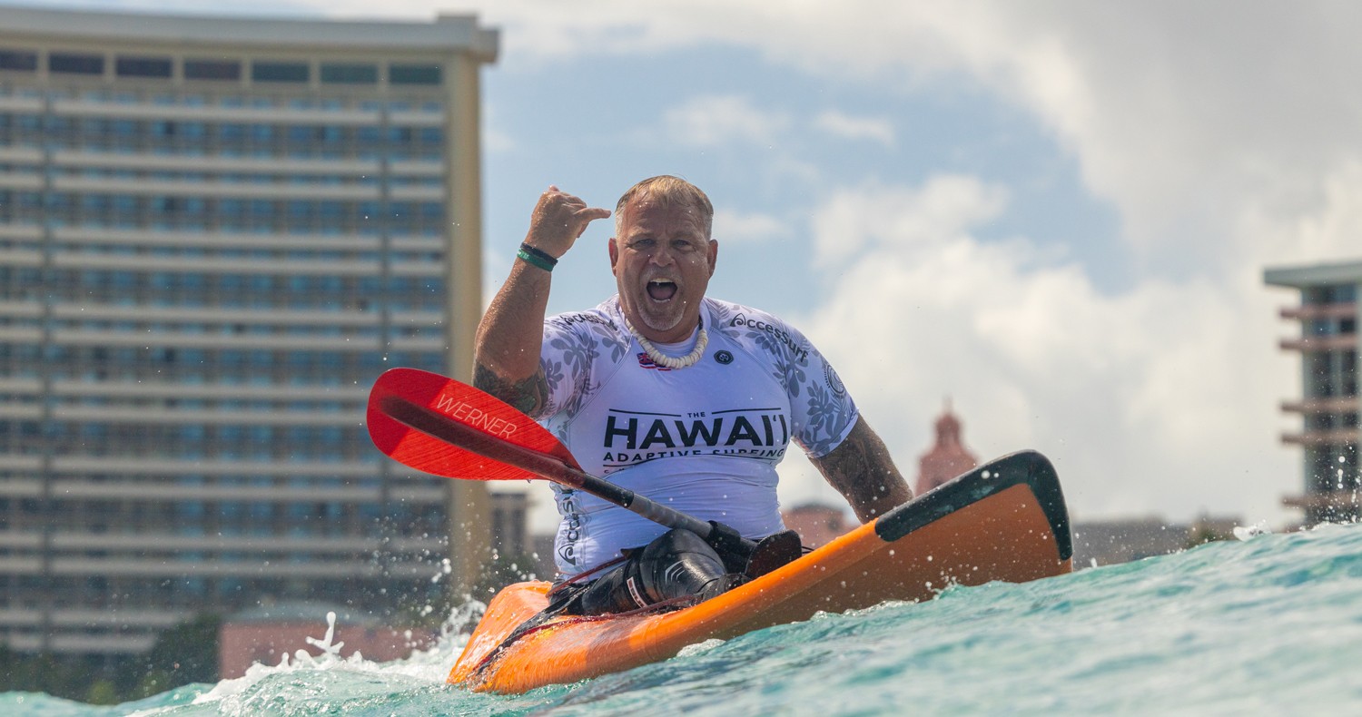 man in open water in kayak doing the shaka "hang loose" sign