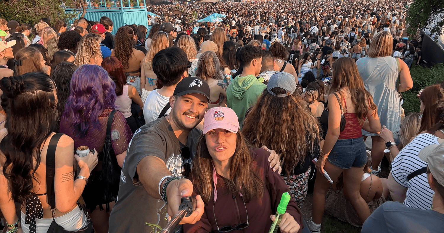 man and woman taking a selfie in a packed festival crowd