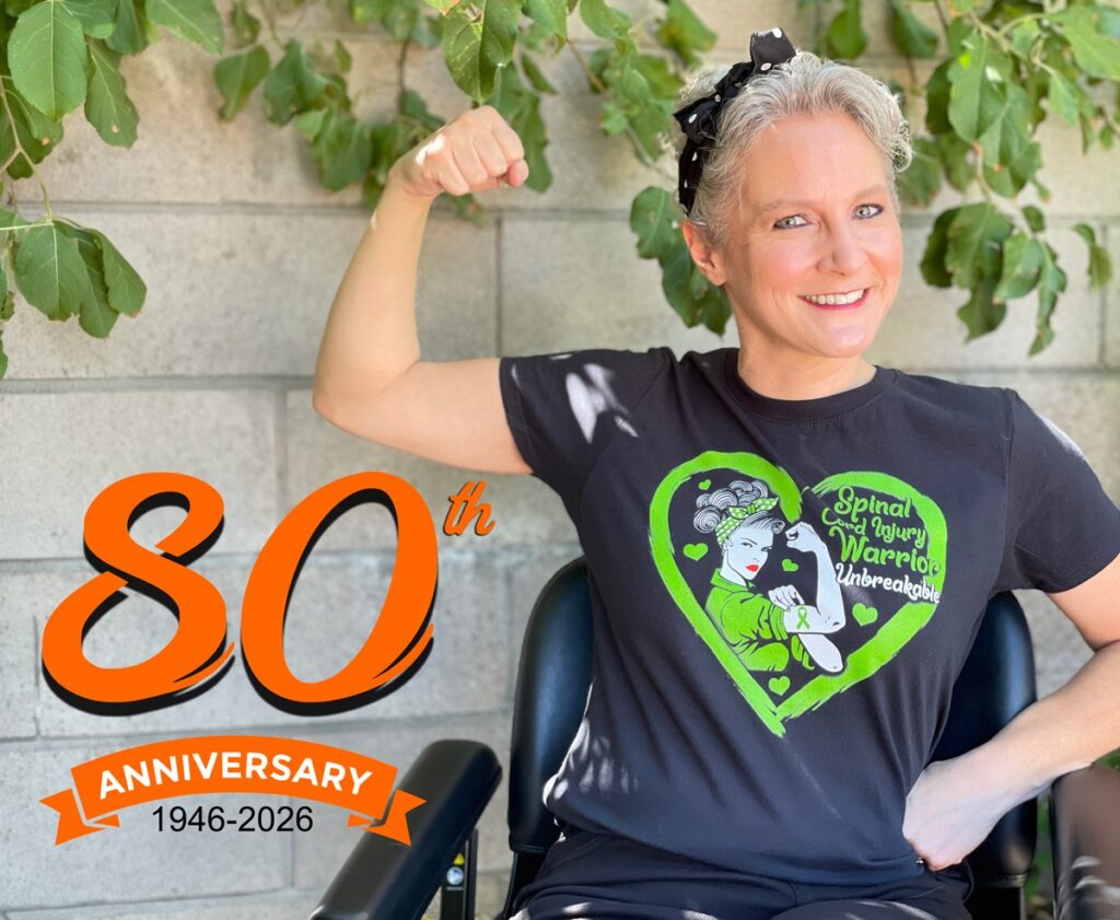 smiling woman in wheelchair with raised fist