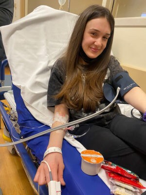 Young woman on hospital bed getting blood drawn
