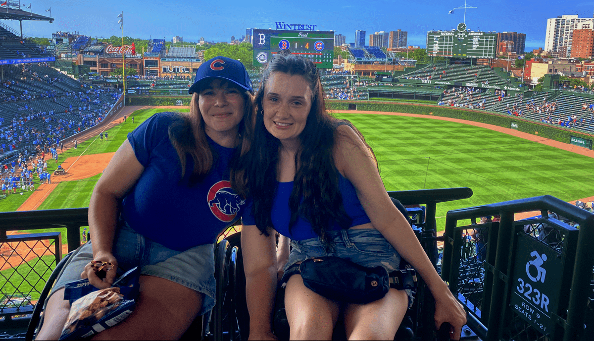 two women in accessible seating section with Wrigley field in the background