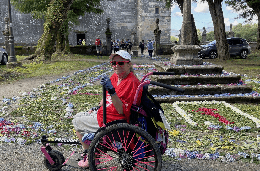 woman in specialized wheelchair in garden at historic building